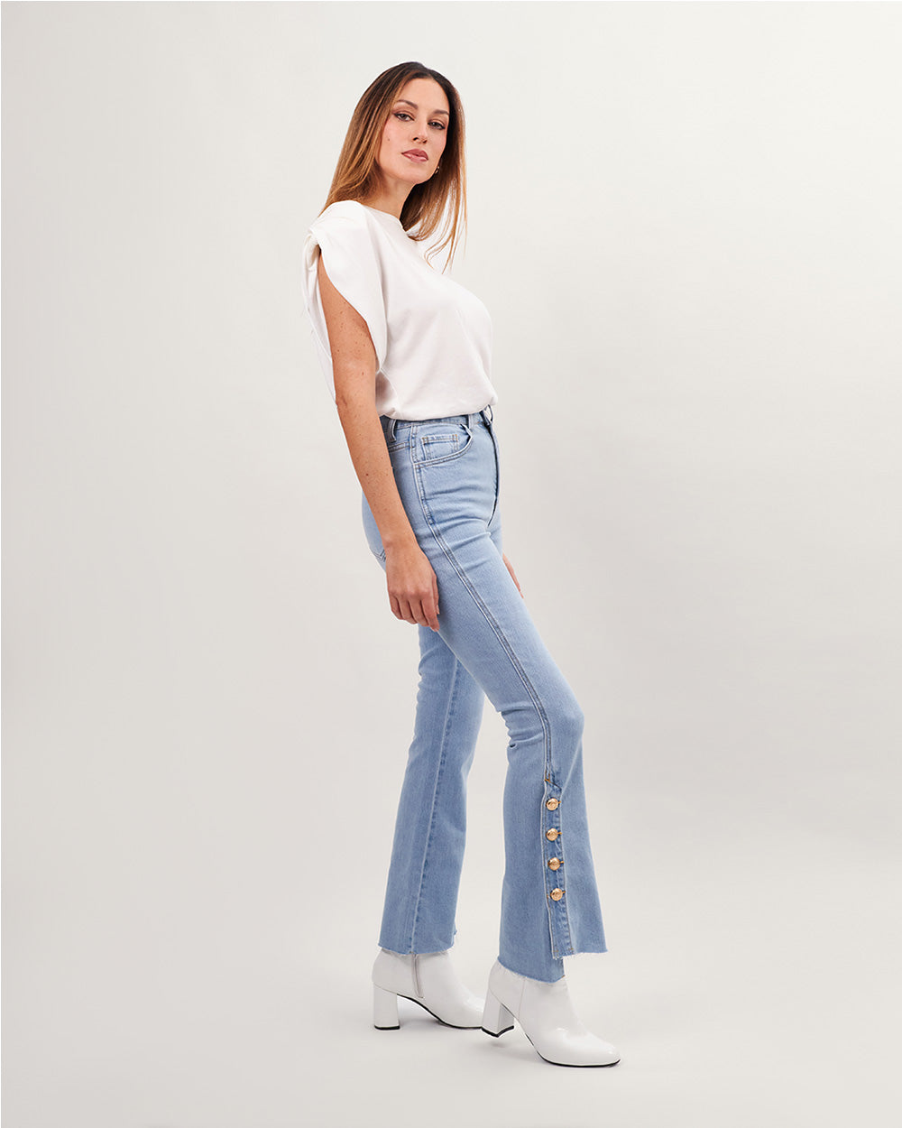 Light blue flared jeans with gold buttons at the bottom